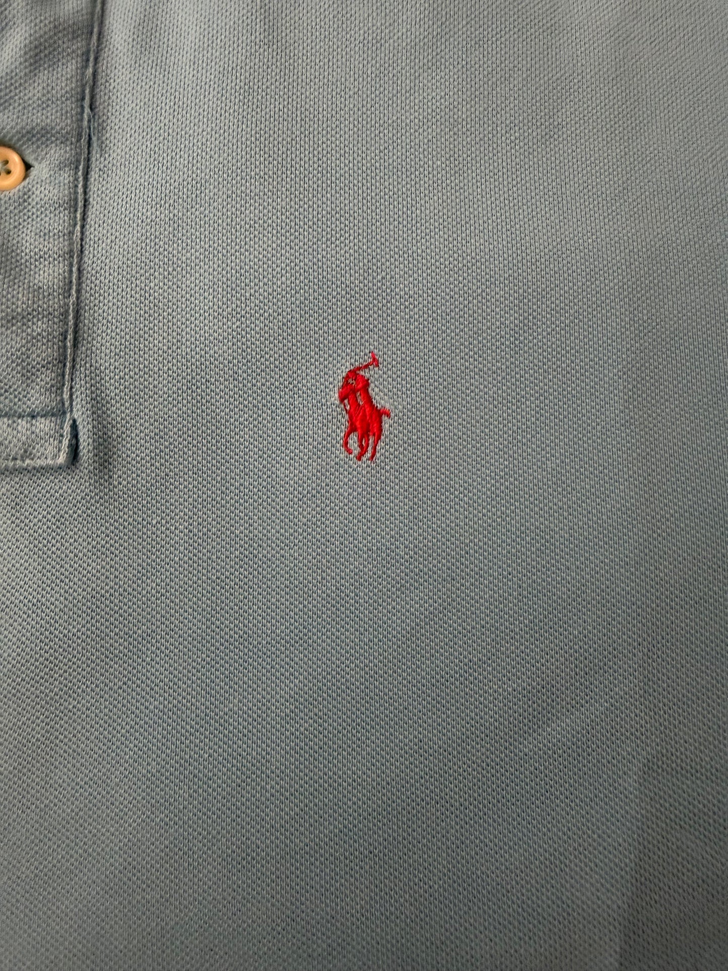 Vintage Polo Ralph Lauren men's light blue button-up polo shirt with a boxy fit, displayed on a hanger.