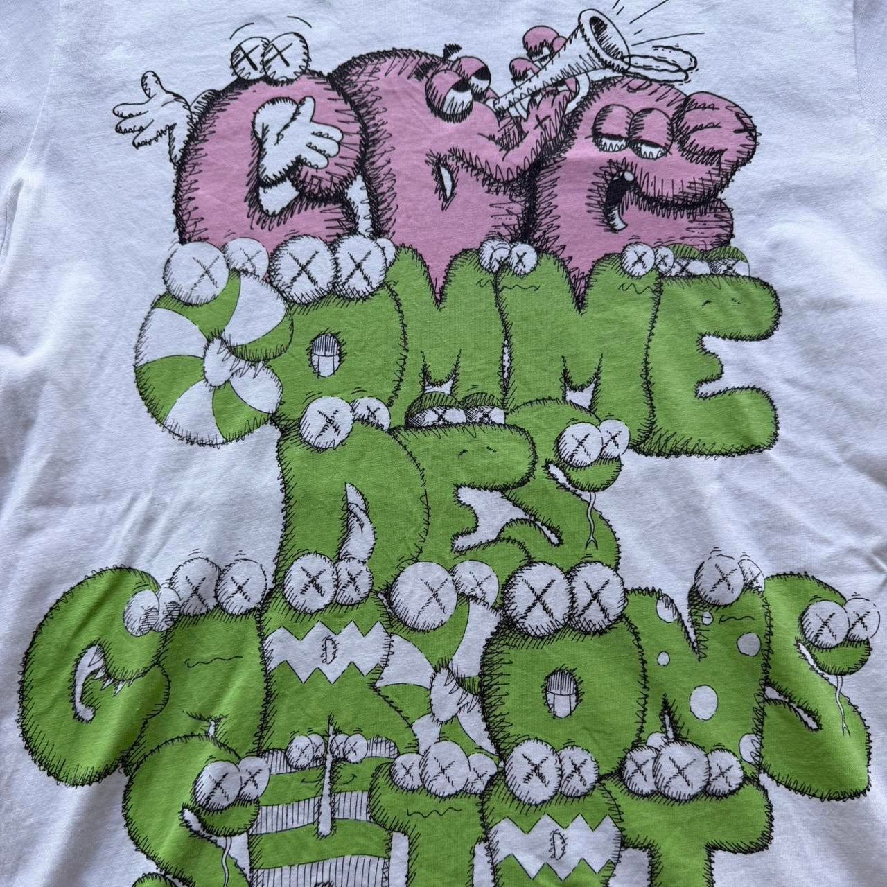 Pink and green graphic T-shirt from Comme des Garçons x KAWS collaboration by The Hennessy Archive, featuring bold KAWS artwork.